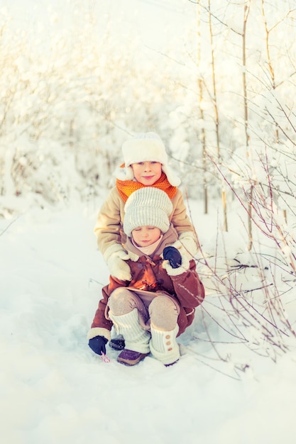 Kinder spielen in einem verschneiten Winterwald