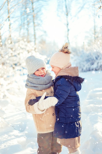 Kinder spielen in einem verschneiten Winterwald