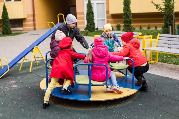 Foto kinder spielen karussell auf dem spielplatz