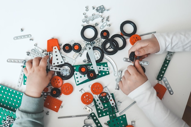 Foto kinder spielen mit den händen eines metallbauers von oben