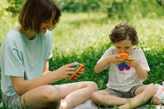 Kinder spielen mit neuem trendigem Pop-It-Spielzeug. Entwicklung der Feinmotorik, Push Bubble Zappeln sensorisches Spielzeug, waschbar und wiederverwendbares Silikonspielzeug zum Stressabbau.