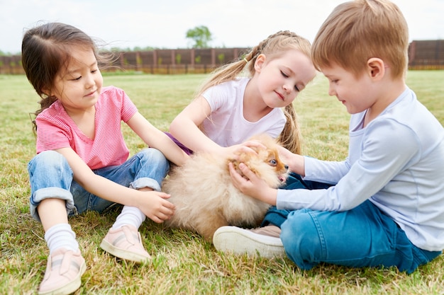 Kinder spielen mit niedlichen Welpen