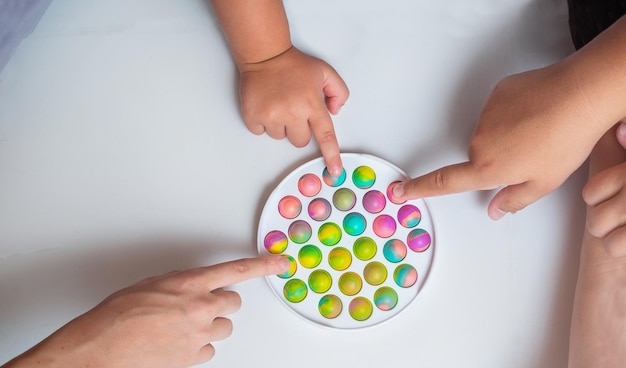 Kinder spielen mit Push-Pop-Spielzeug auf dem Boden