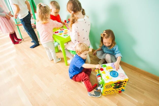 Kinder spielen mit Spielzeug auf dem Holzboden