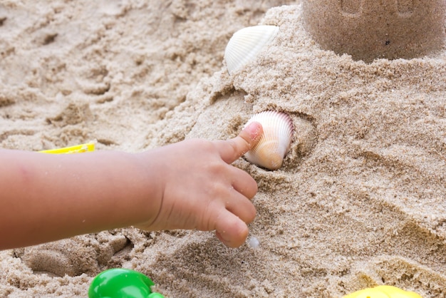 Kinder spielen Spielzeug auf Sand.