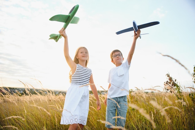 Kinder spielen Spielzeugflugzeugkonzept von glücklichen Kinderkindern, die davon träumen, zu fliegen und Pilot zu werden