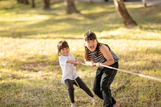 Kinder spielen Tauziehen im Park auf Sunsut