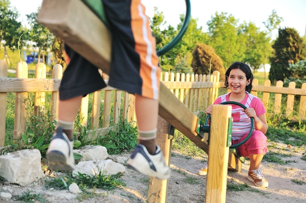 Kinder spielen Wippe am Spielplatz, Jungen und Mädchen