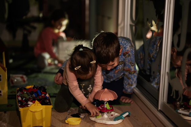 Kinder spielen zu Hause während eines Stromausfalls mit alternativer Beleuchtung