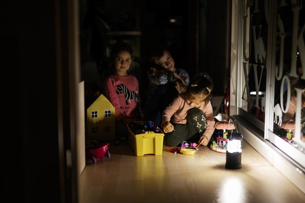 Kinder spielen zu Hause während eines Stromausfalls mit Laterne