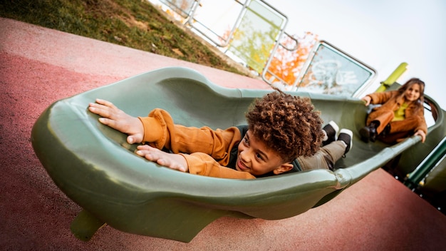 Kinder spielen zusammen auf einer Rutsche im Freien