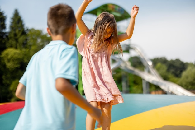 Foto kinder springen auf einem aufblasbaren trampolin im vergnügungspark