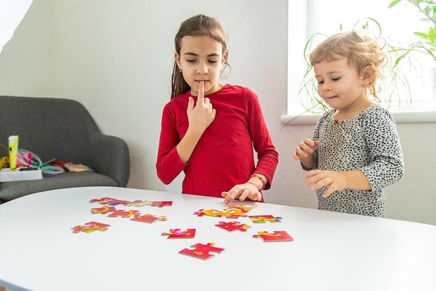 Kinder stellen ein Puzzle auf dem Tisch zusammen Selektiver Fokus