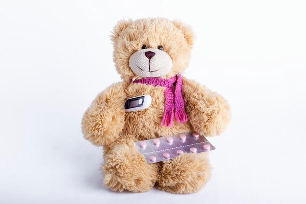 Kinder-Stofftier-Teddybär mit Pillen und Thermometer Kinderkrankheit Pädiatrie-Konzept