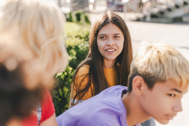 Kinder, Teenager, die auf städtischen Straßen reden, attraktive Studenten, die sich im Freien entspannen