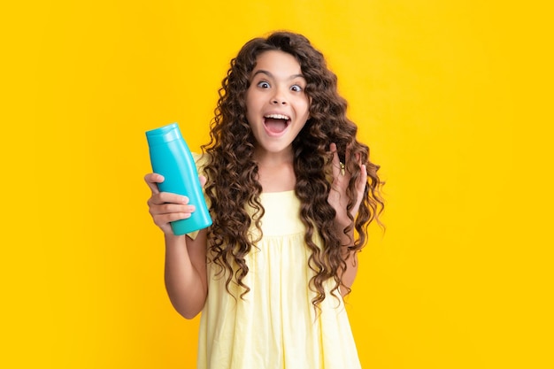 Kinder-Teenager-Mädchen mit Shampoos, Spülungen und Duschgel Lange Haarpflege von Teenagern Präsentieren von kosmetischen Produkt-Shampoo-Flaschen Aufgeregter Teenager, froh, erstaunt und überglücklich