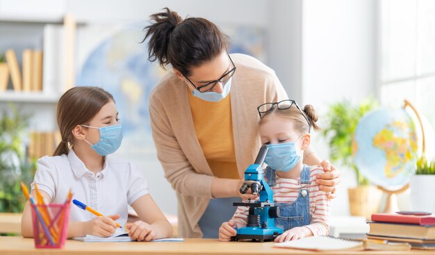 Kinder tragen Gesichtsmasken, die im Unterricht lernen