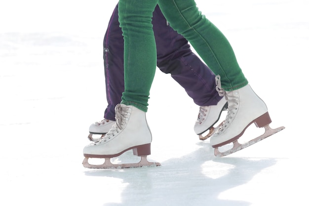 Foto kinder- und erwachsenenschlittschuhe auf der eisbahn. urlaubshobbys und sport