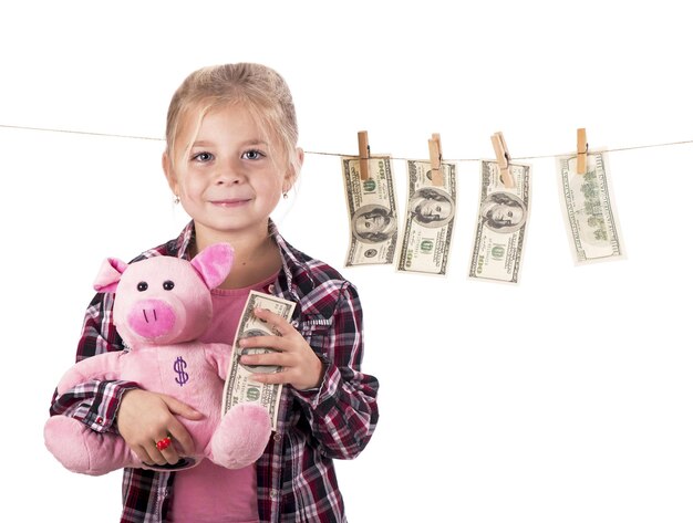 Kinder und Geld Mädchen mit einem Sparschwein Girl hängenden Dollarnoten an einem Seil isolated on white Background