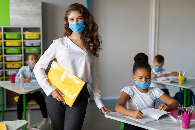 Kinder und Lehrer schützen sich mit medizinischen Masken