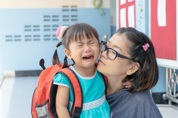 Kinder und Mutter, die am ersten Tag weinen, gehen in die Vorschule
