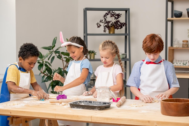 Kinder zeigen auf einen der Kekse auf dem Tablett