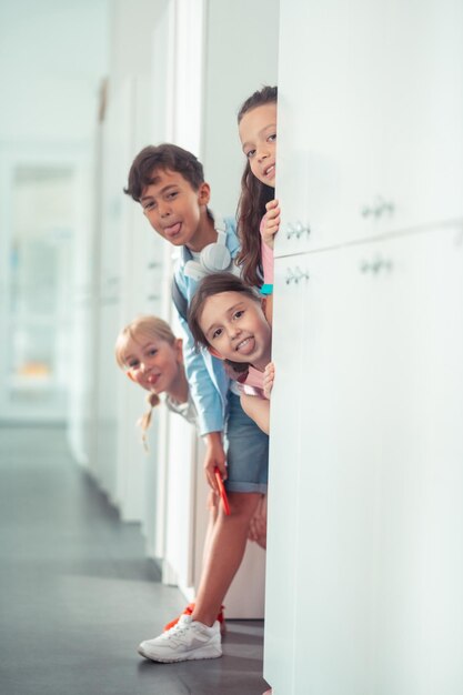 Kinder zeigen ihre Zungen und haben Spaß in der Schulpause