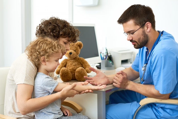 Kinderarzt arbeitet mit Kind im Büro