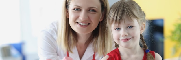 Kinderarzt Arzt und kleines Mädchen halten Schwein Sparschwein Kinder Krankenversicherung