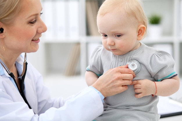 Kinderarzt kümmert sich um Baby im Krankenhaus Kleines Mädchen wird vom Arzt mit Stethoskop untersucht Krankenversicherung und Hilfskonzept