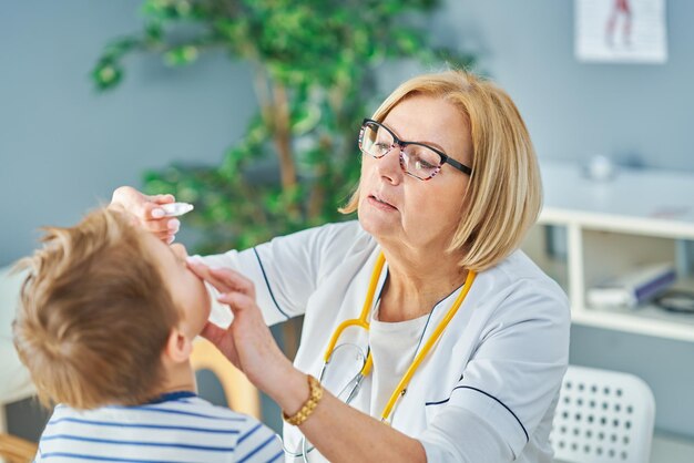 Kinderarzt untersucht kleine Kinder in der Klinik. Foto in hoher Qualität
