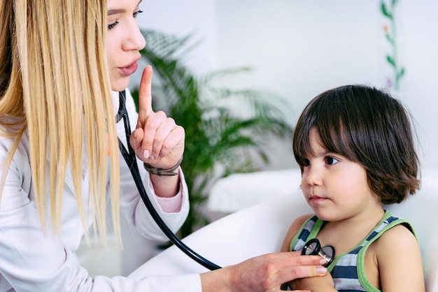 Kinderarzt untersucht kleinen Jungen mit Stethoskop
