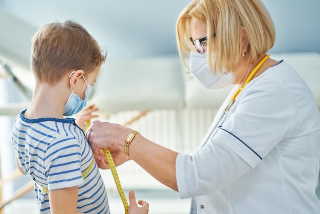 Kinderarzt untersucht Kleinkinder im Klinikmaßband. Foto in hoher Qualität