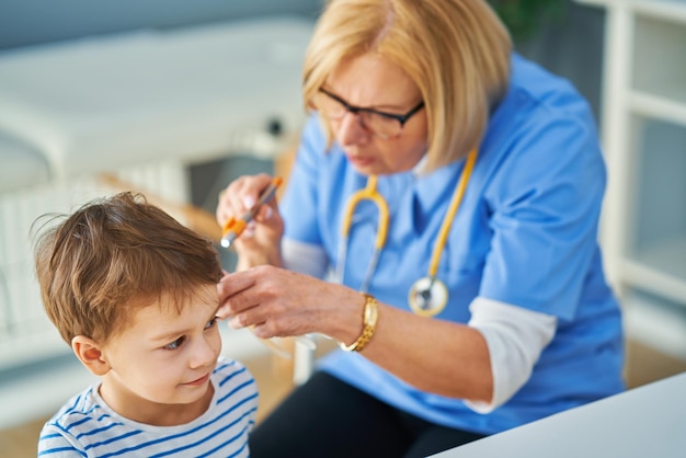 Kinderarzt untersucht Kleinkinder in Klinikohren. Foto in hoher Qualität