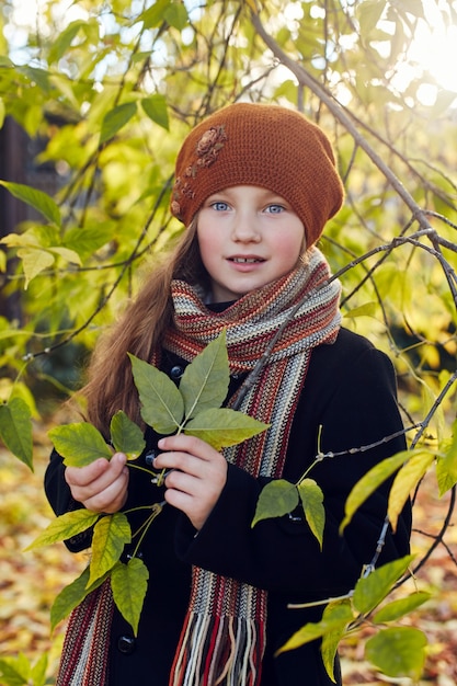 Kinderbaby in Retro-Herbstfrühlingskleidung. Kleines Kind sitzt lächelnd in der Natur, Schal um den Hals, kühles Wetter. Helle Emotionen auf seinem Gesicht. Russland, Swerdlowsk, 29. September 2018