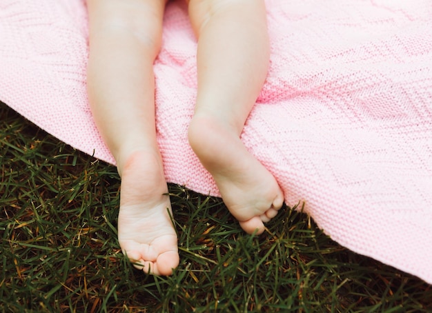 Kinderbeine Nahaufnahme Das Kind liegt im Sommer auf dem Rasen im Park