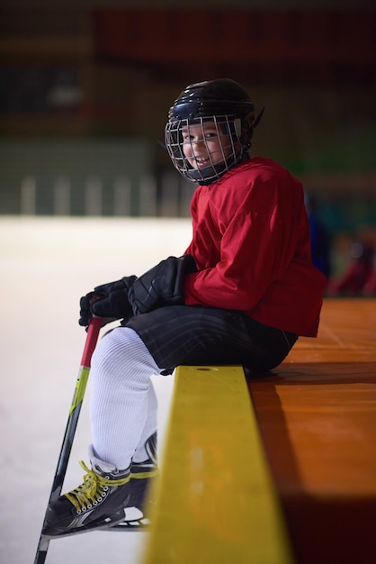 kindereishockeyspieler, gruppen von personen, teamfreunde, die auf der bank warten und sich entspannen, um das spiel zu starten