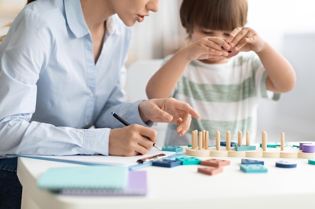 Kinderentwicklungskurse kleiner Junge spielt logisches Spiel im Büro des Psychologen, nicht wiederzuerkennen