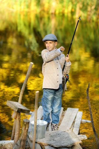 Kinderfischen in einem Fluss, der auf einem hölzernen Ponton sitzt