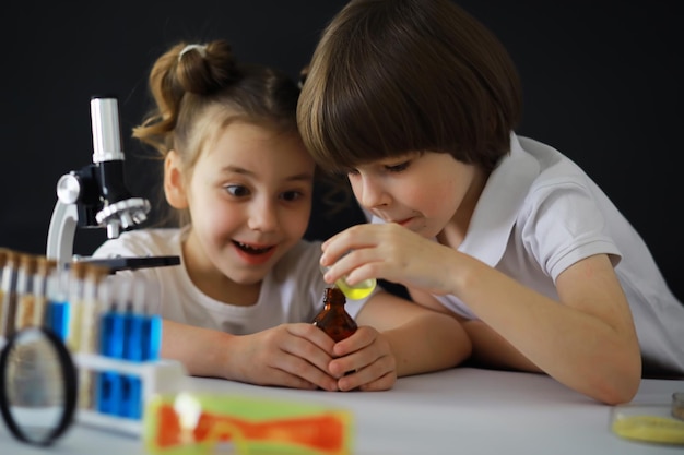 Kinderforscher Schüler im Labor experimentieren Jungen und Mädchen experimentieren mit einem Mikroskop