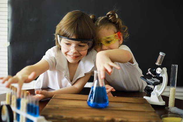 Kinderforscher Schüler im Labor experimentieren Jungen und Mädchen experimentieren mit einem Mikroskop