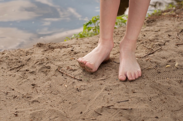 Kinderfüße barfuß hautnah ohne Socken und Schuhe im Sand am Strand