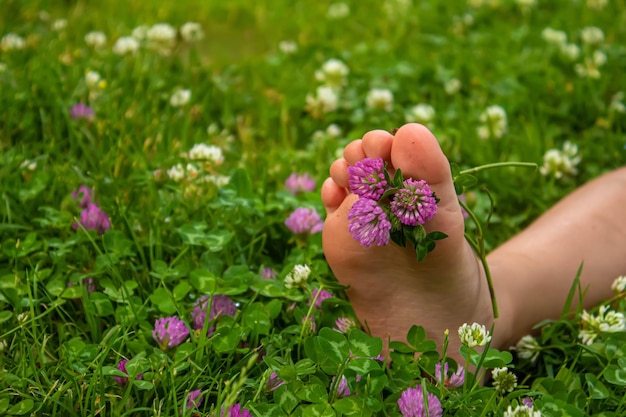 Kinderfüße mit einem Muster aus Farben lächeln auf dem grünen Gras Selektiver Fokus