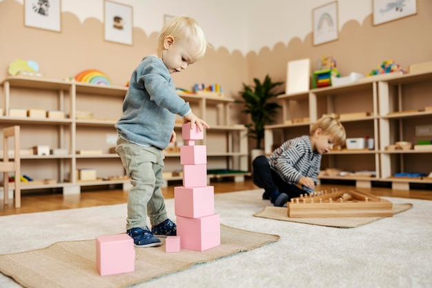 Kindergartenkinder spielen mit Holzspielzeug und lernen durch das Spiel