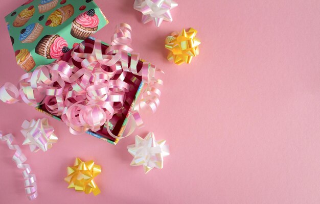 Kindergeschenk mit buntem Konfetti auf dem rosafarbenen HintergrundDraufsicht