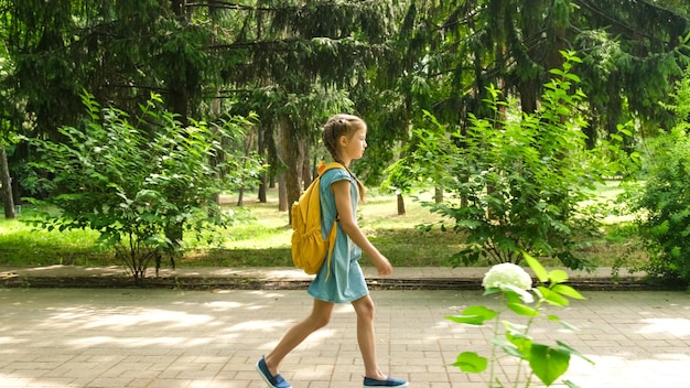 Kindergrundschüler gehen am ersten Herbsttag durch den Park zur Schule
