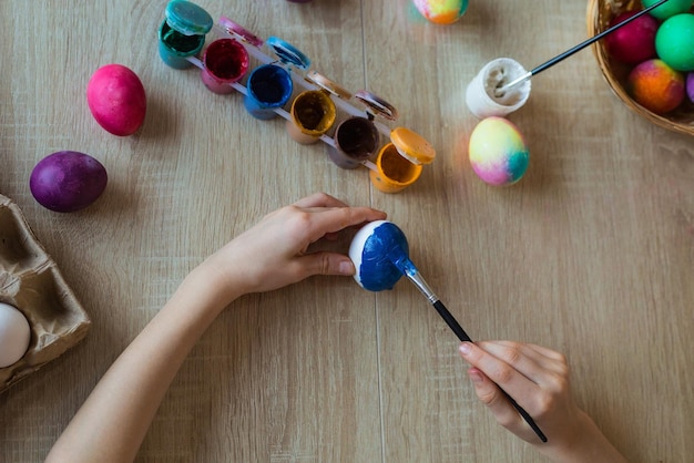 Kinderhände closeup malen Eier mit Gouache Ein Mädchen malt Ostereier mit Farben