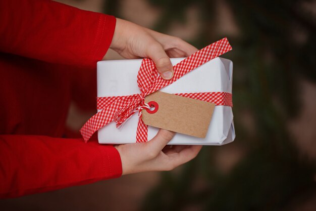 Kinderhände, die Geschenk-Weihnachtsbox halten.