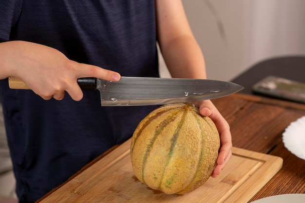 Foto kinderhände halten eine melone und ein messer