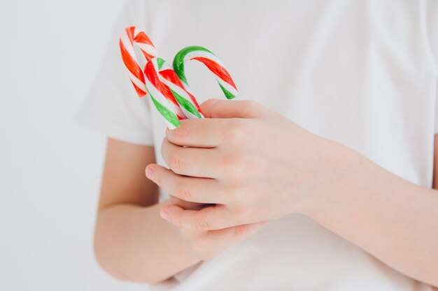 Kinderhände halten Zuckerstangen